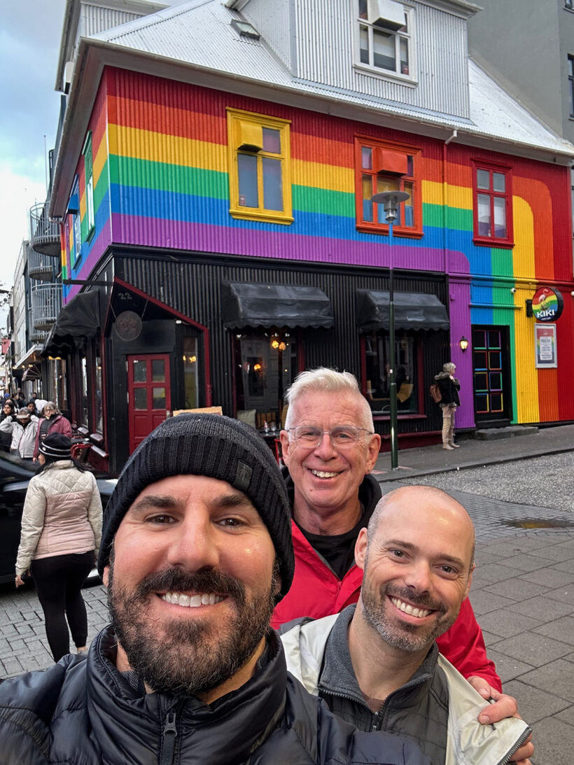 Cory and travelers in front of rainbow colored building