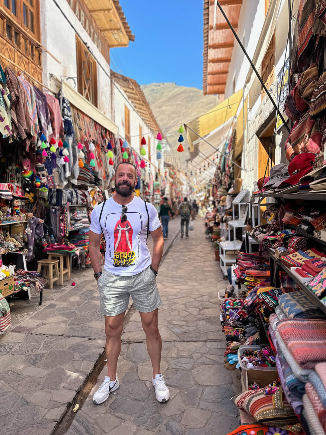 A Pivot Trip traveler stands in a colorful street market